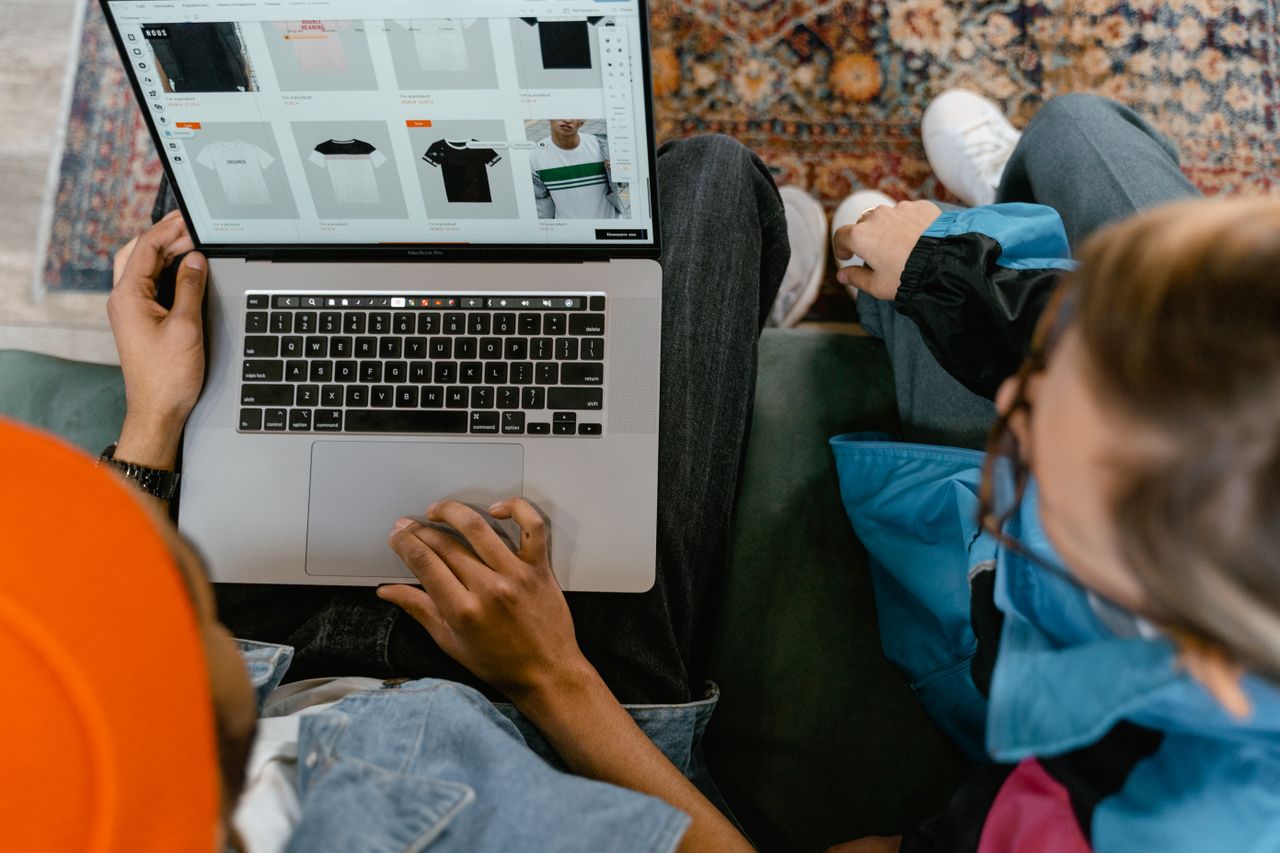why-choose-us Two people browsing online clothing store on a laptop from above.